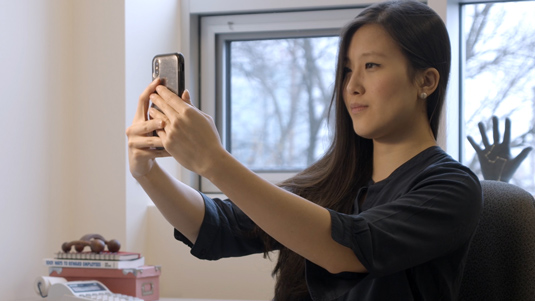 Femme prenant une photo selfie en direct avec son smartphone.