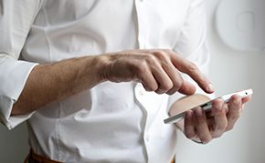 A person tapping on their smartphone.